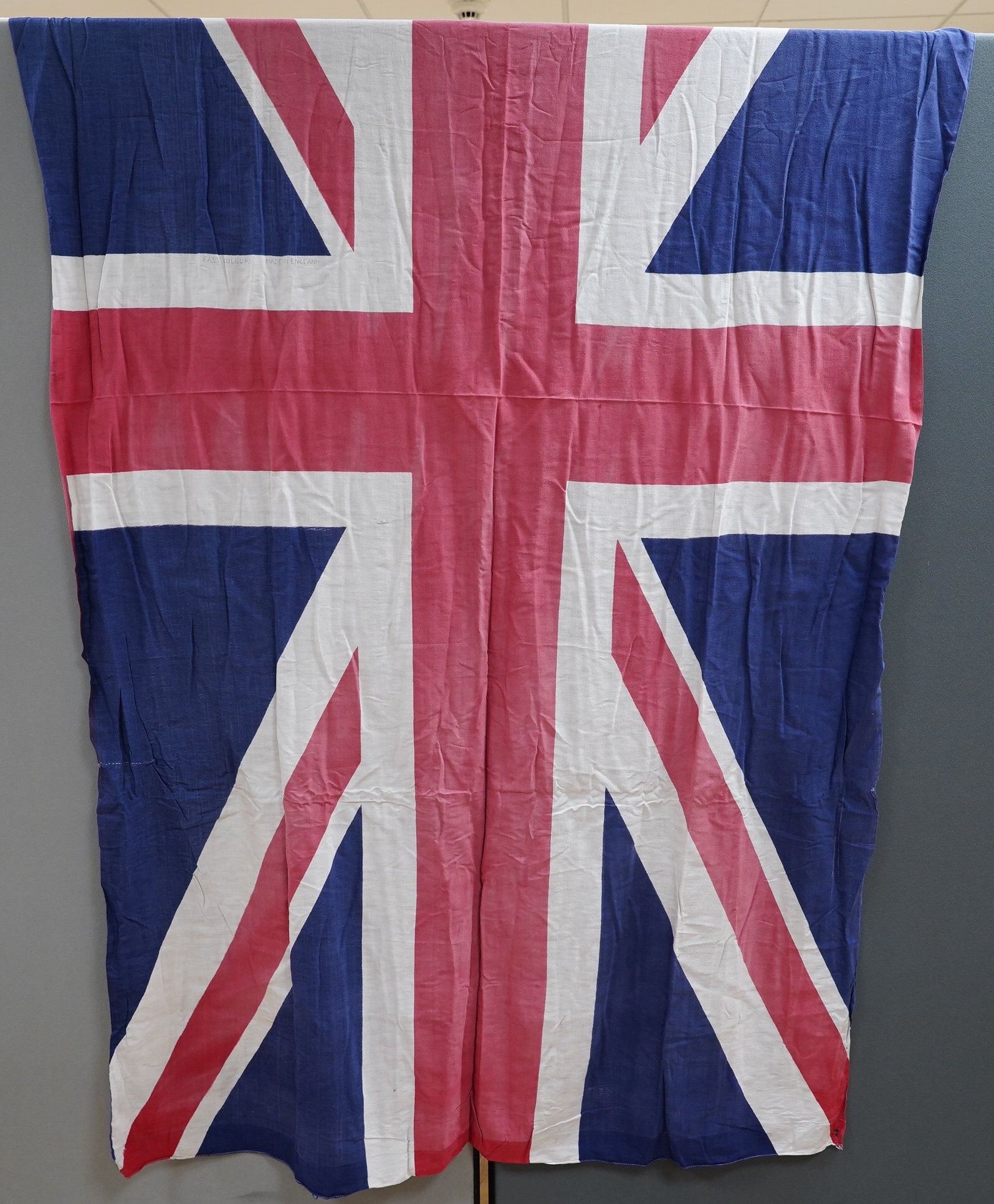 Four early to mid 20th century flags including; two Union Jack flags, a British naval ensign and an American confederate flag, 62 x 86cm. Condition - poor to fair